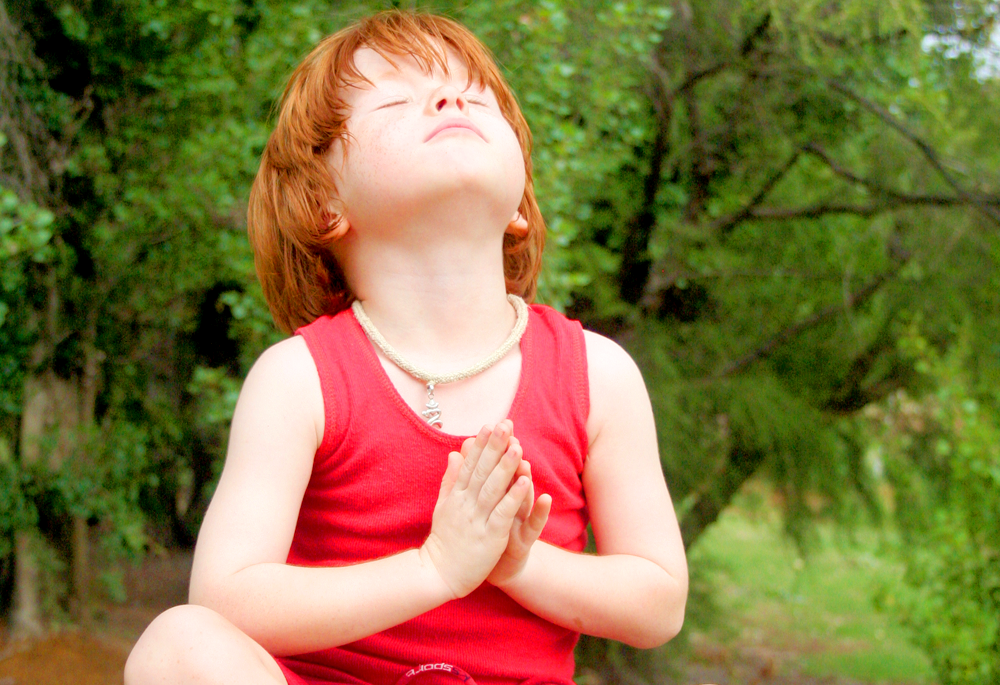A child meditating in the forest